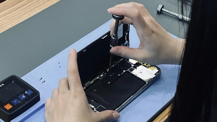 技師現場拆修 iPhone，說明屏東修手機資料安全與透明維修流程